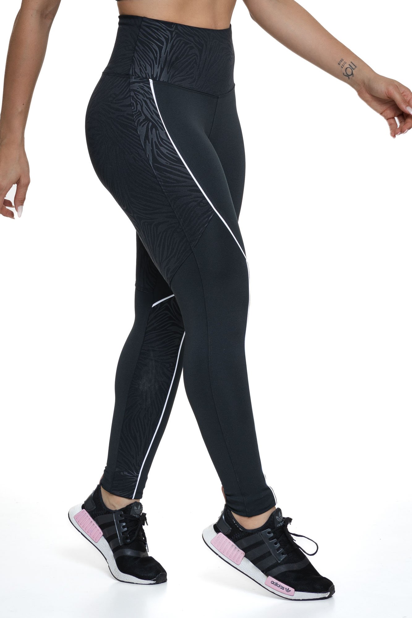 Legging feminina texturizada preta vista de lado com cintura alta e tecido flexível, ideal para conforto e performance nas atividades físicas.