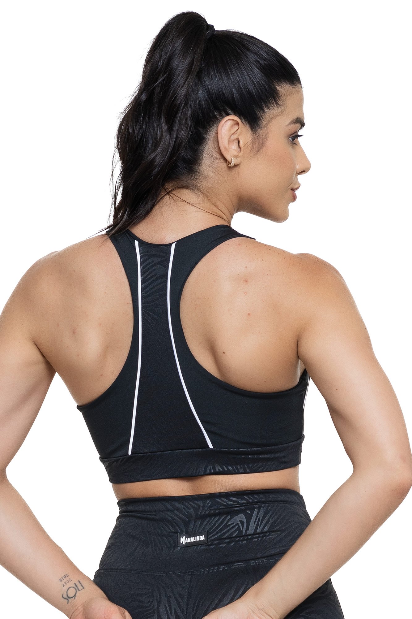 Top fitness preto texturizado visto de costas, com caimento confortável e detalhes em relevo, perfeito para treinos com estilo.
