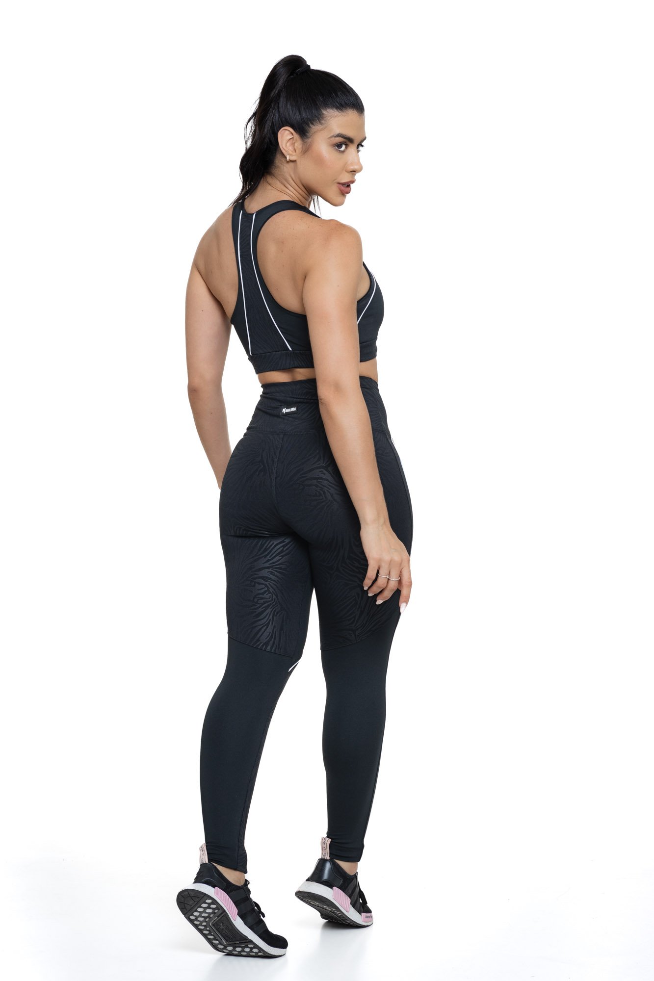 Conjunto de academia feminino preto texturizado visto de costas, composto por top e legging, ideal para treinos com conforto e elegância.