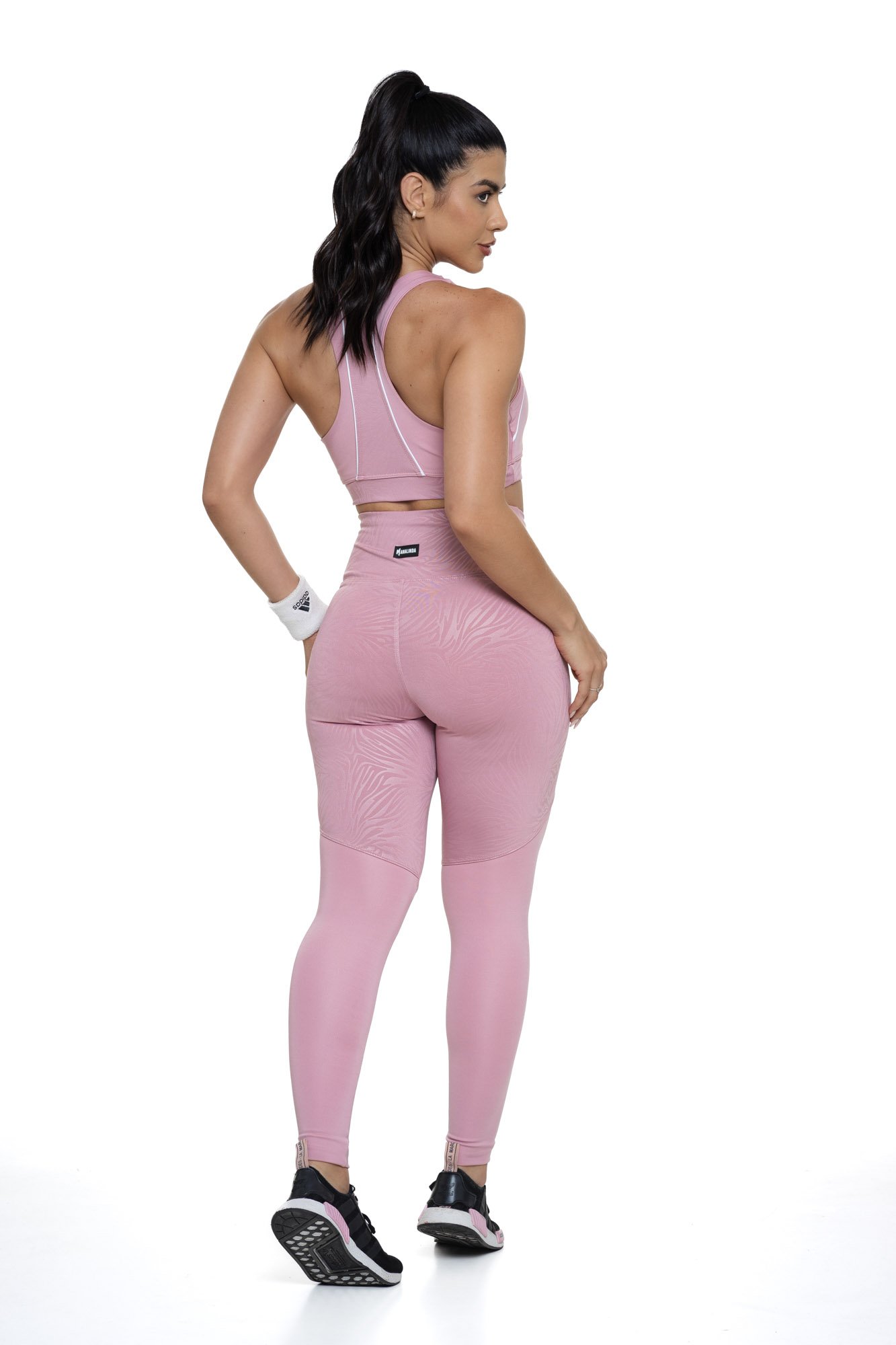 Conjunto de academia feminino rosa claro texturizado visto de costas, composto por top e legging, ideal para treinos com conforto e elegância.