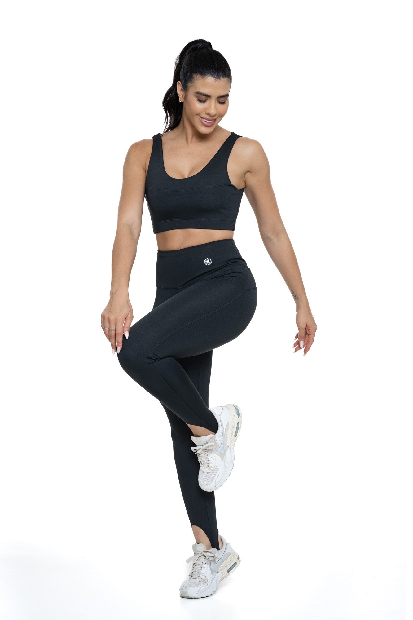 Conjunto fitness com legging preta de pezinho visto de frente, projetado para conforto e mobilidade, ideal para treinos com estilo e praticidade.