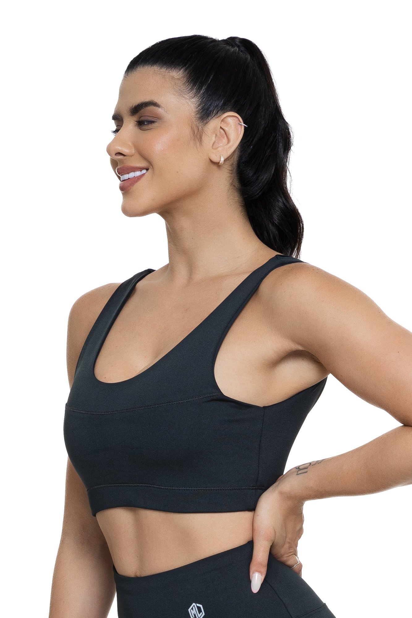 Conjunto fitness com legging preta de pezinho visto de lado, projetado para conforto e mobilidade, ideal para treinos com estilo e praticidade.