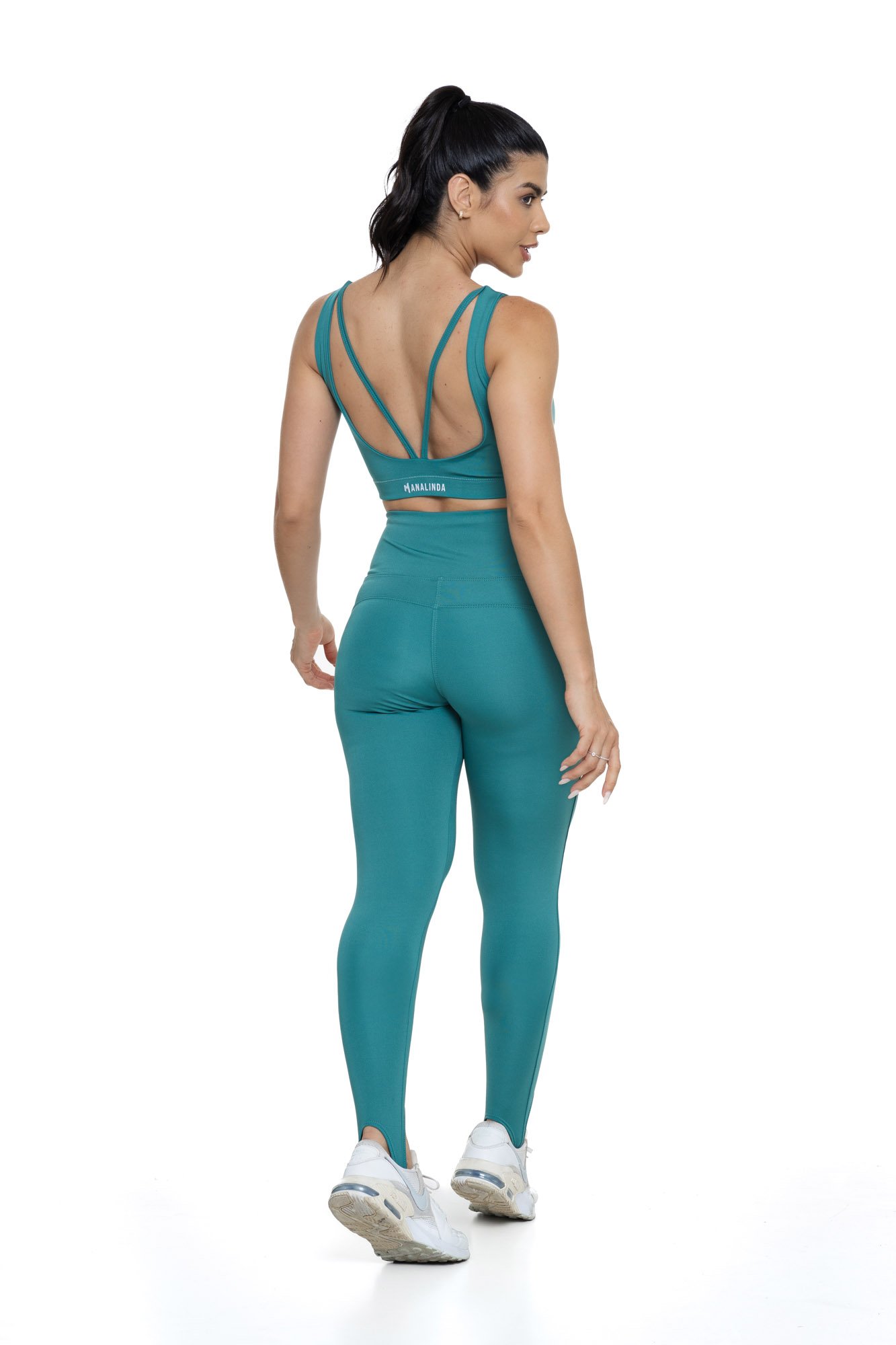 Conjunto fitness com legging verde de pezinho visto de costas, projetado para conforto e mobilidade, ideal para treinos com estilo e praticidade.