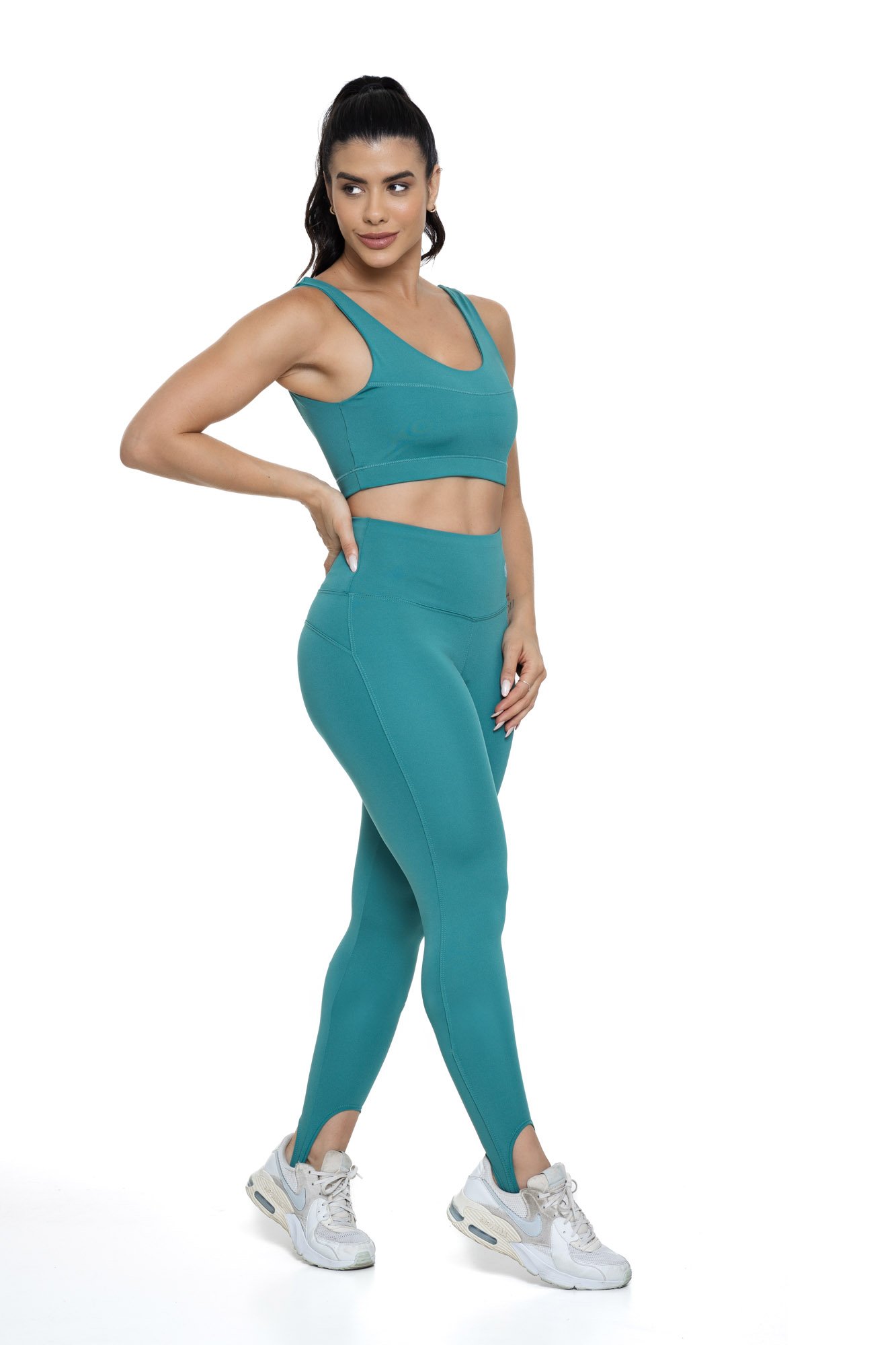 Conjunto fitness com legging verde de pezinho visto de lado, projetado para conforto e mobilidade, ideal para treinos com estilo e praticidade.