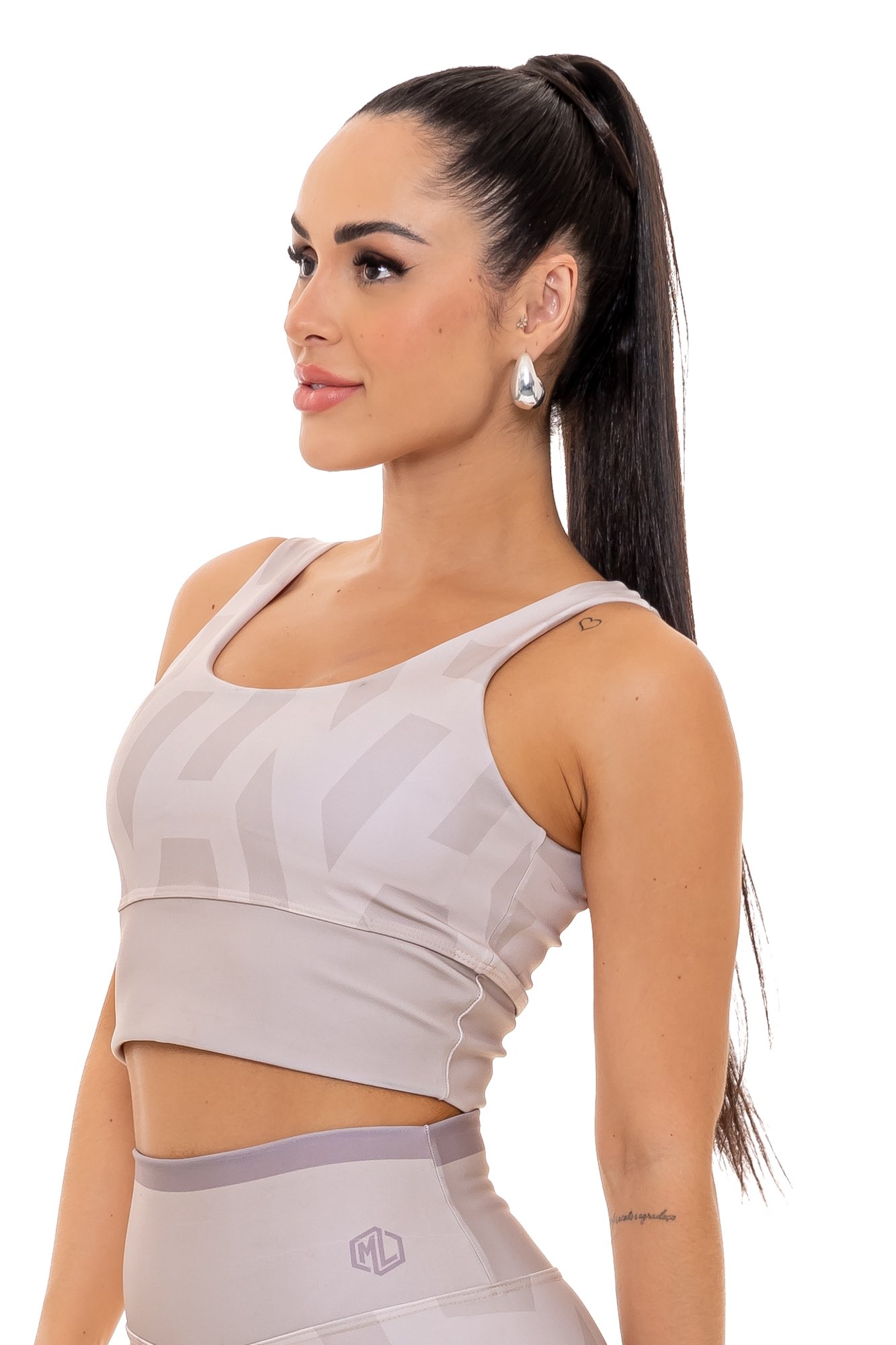 Top fitness bege com estampa digital visto de lado, com modelagem anatômica, perfeito para treinos com estilo e conforto.