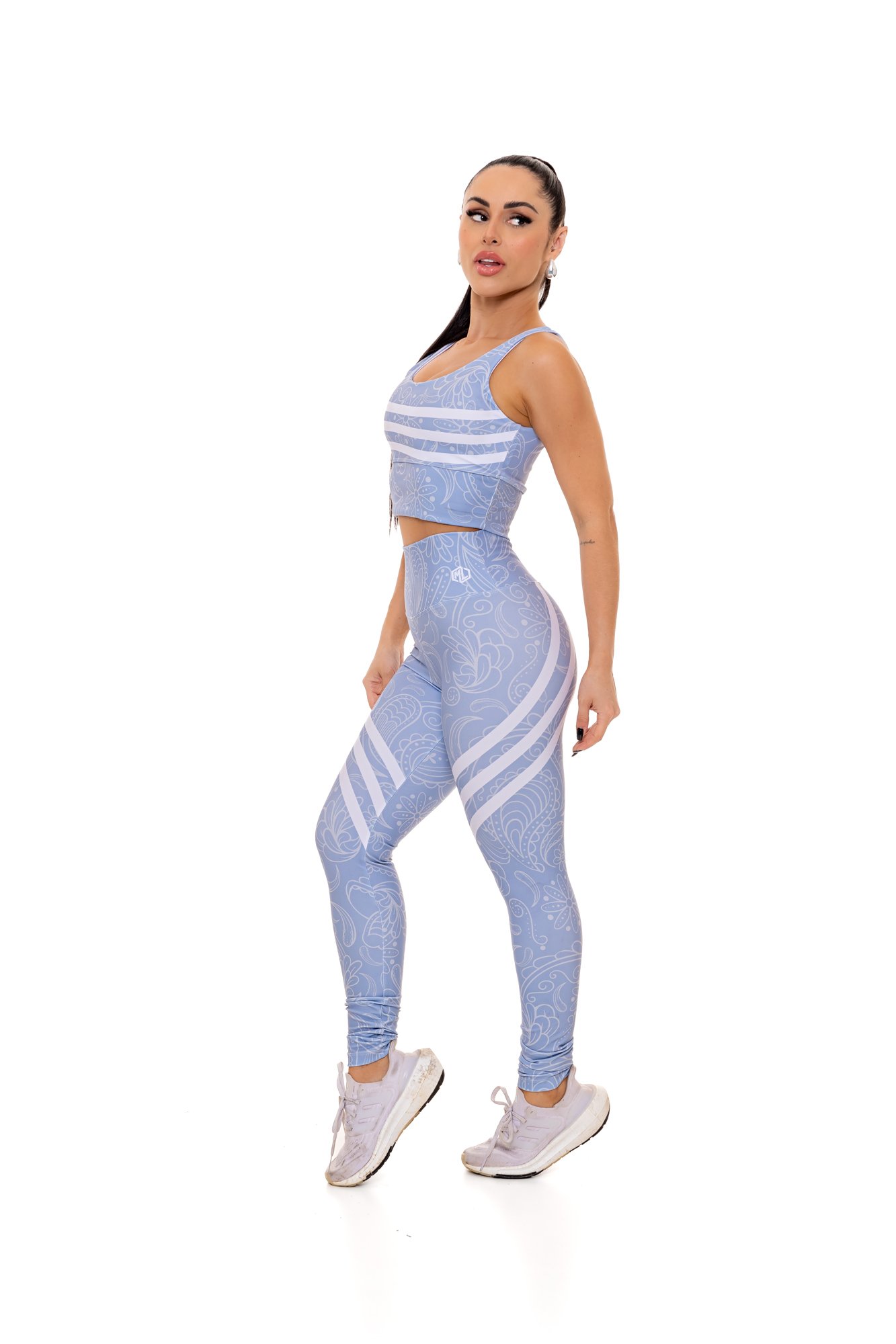 Conjunto fitness azul claro com estampa digital visto de lado, com modelagem anatômica, perfeito para treinos com estilo e conforto.