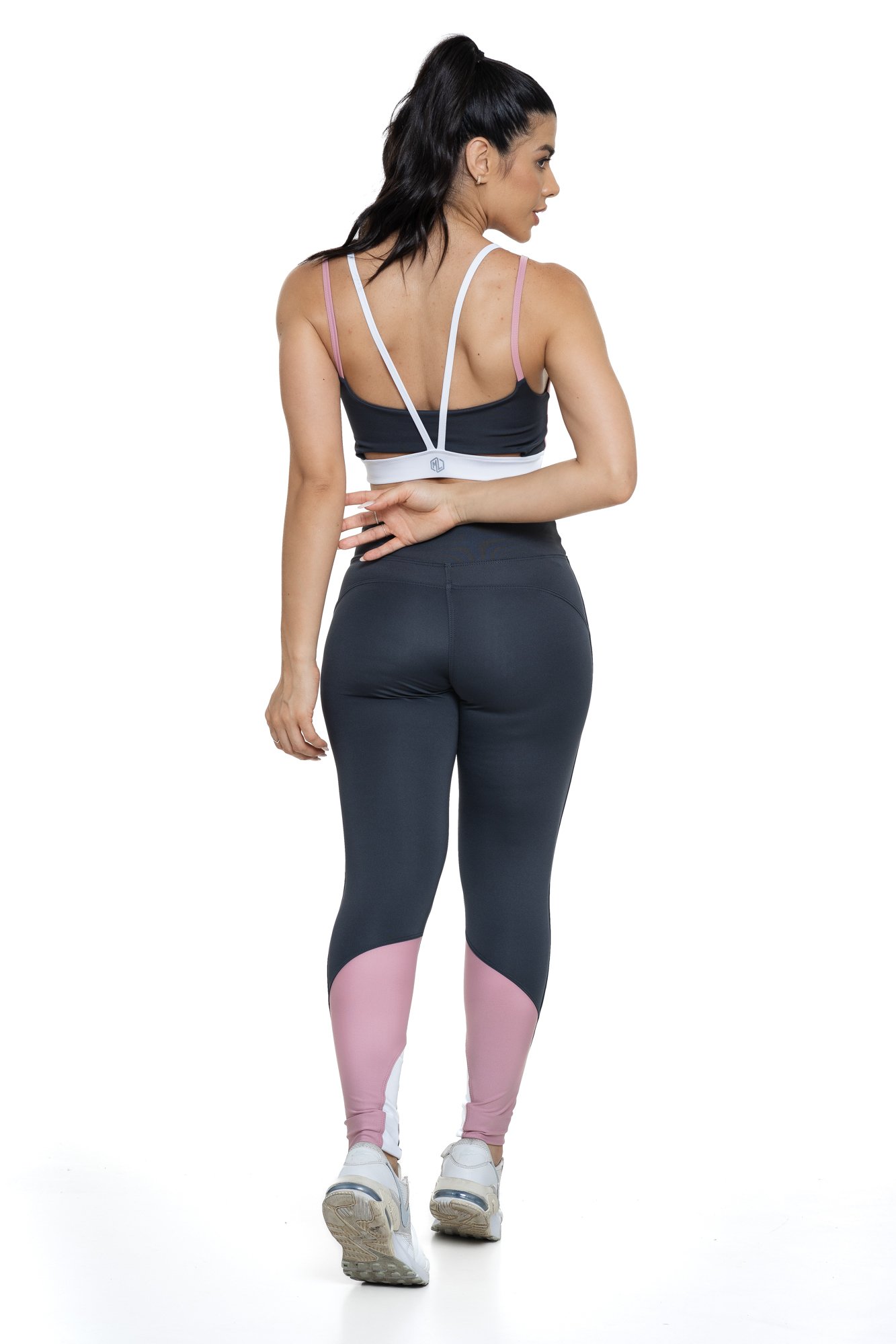 Conjunto fitness cinza e rosa claro com recortes visto de costas, projetado para conforto e mobilidade, ideal para treinos com estilo e praticidade.