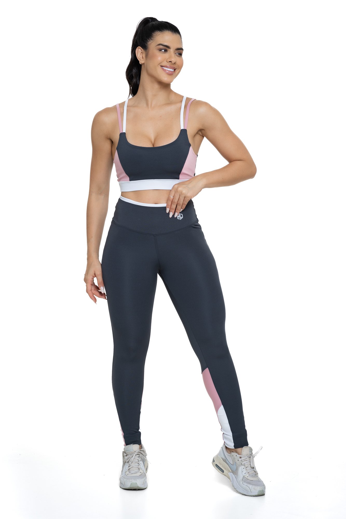 Conjunto fitness cinza e rosa claro com recortes visto de frente, projetado para conforto e mobilidade, ideal para treinos com estilo e praticidade.