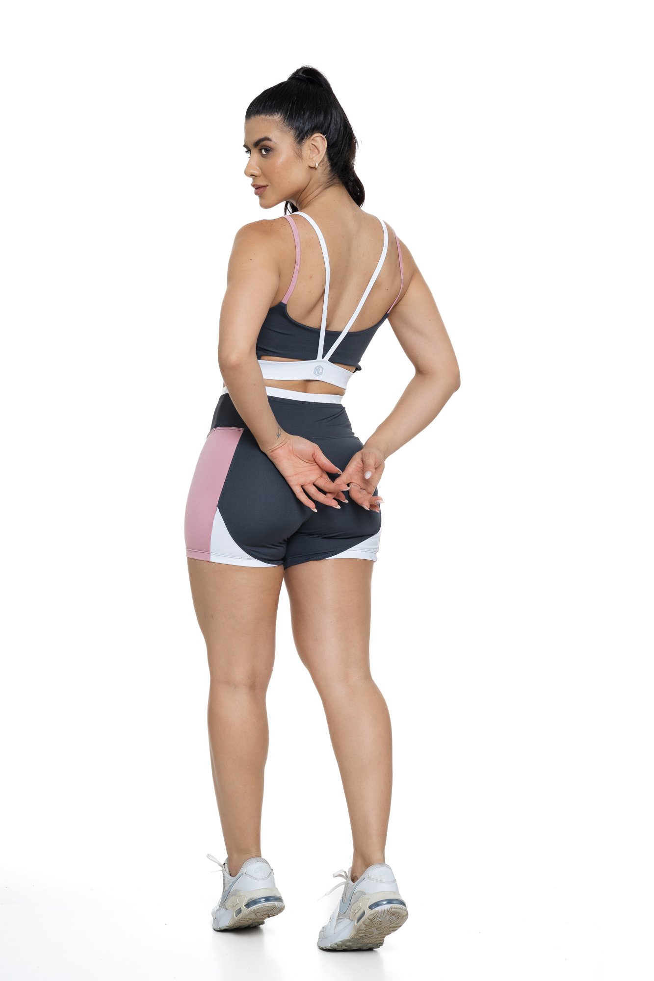 Conjunto bermuda fitness cinza e rosa claro com recortes visto de frente, ideal para treinos com estilo e praticidade.