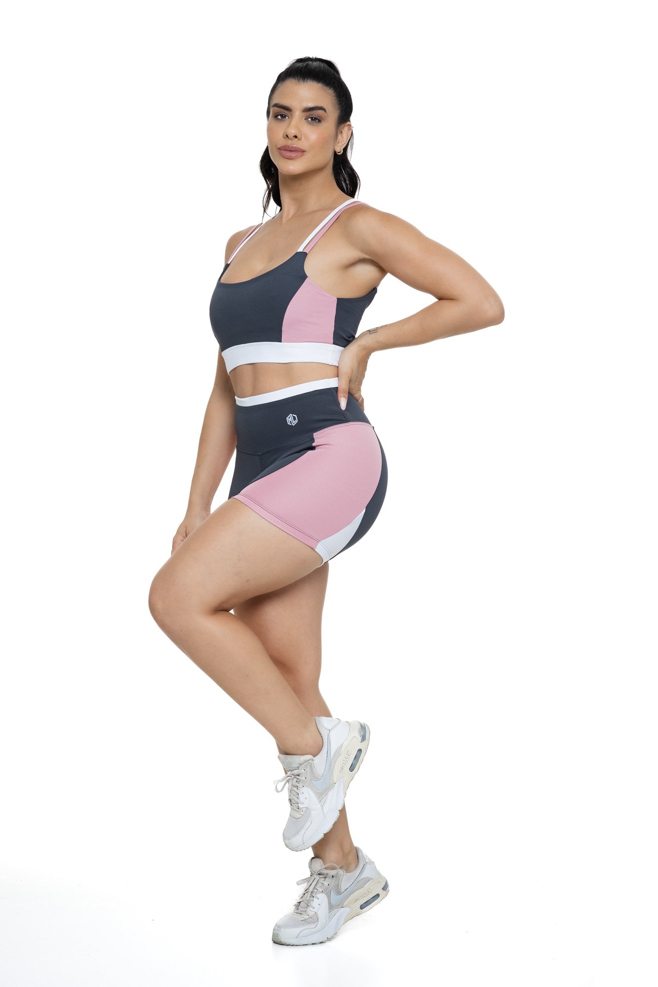 Conjunto bermuda fitness cinza e rosa claro com recortes visto de frente, ideal para treinos com estilo e praticidade.