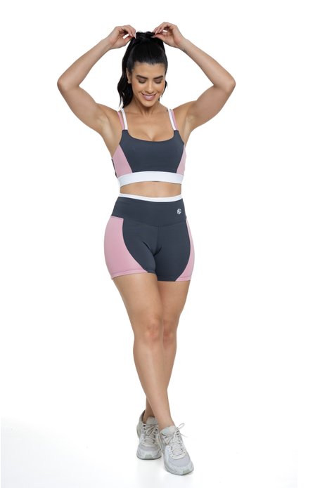 Conjunto bermuda fitness cinza e rosa claro com recortes visto de frente, ideal para treinos com estilo e praticidade.