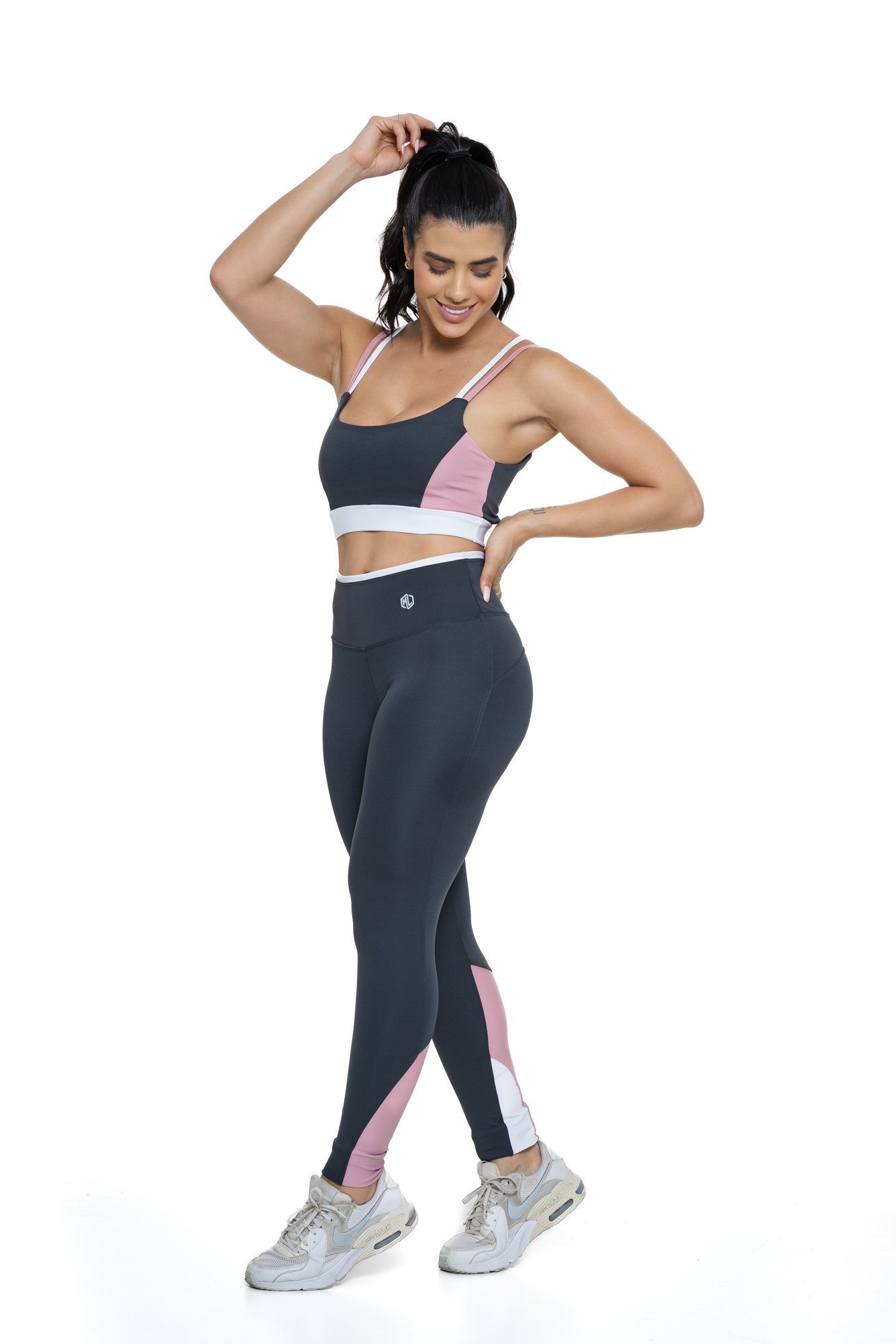 Conjunto fitness cinza e rosa claro com recortes visto de lado, projetado para conforto e mobilidade, ideal para treinos com estilo e praticidade.
