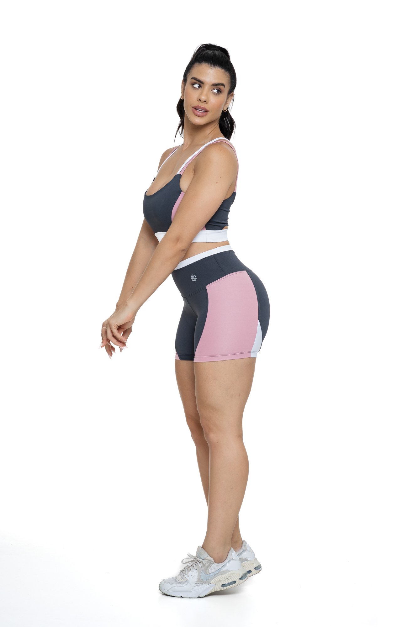 Conjunto bermuda fitness cinza e rosa claro com recortes visto de lado, ideal para treinos com estilo e praticidade.