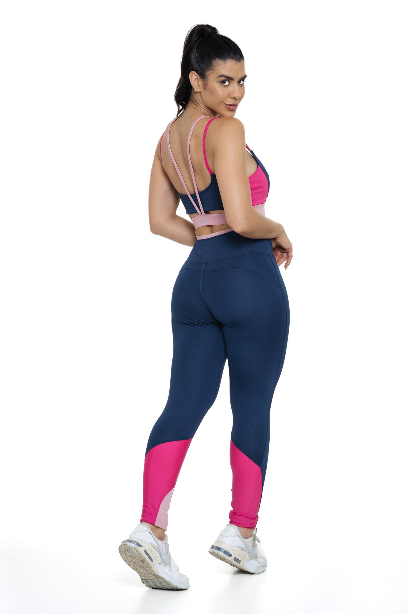 Conjunto fitness azul marinho e rosa com recortes visto de costas, projetado para conforto e mobilidade, ideal para treinos com estilo e praticidade.