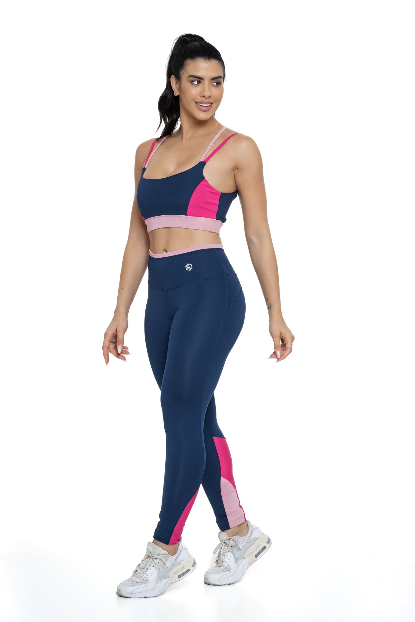 Conjunto fitness azul marinho e rosa com recortes visto de lado, projetado para conforto e mobilidade, ideal para treinos com estilo e praticidade.
