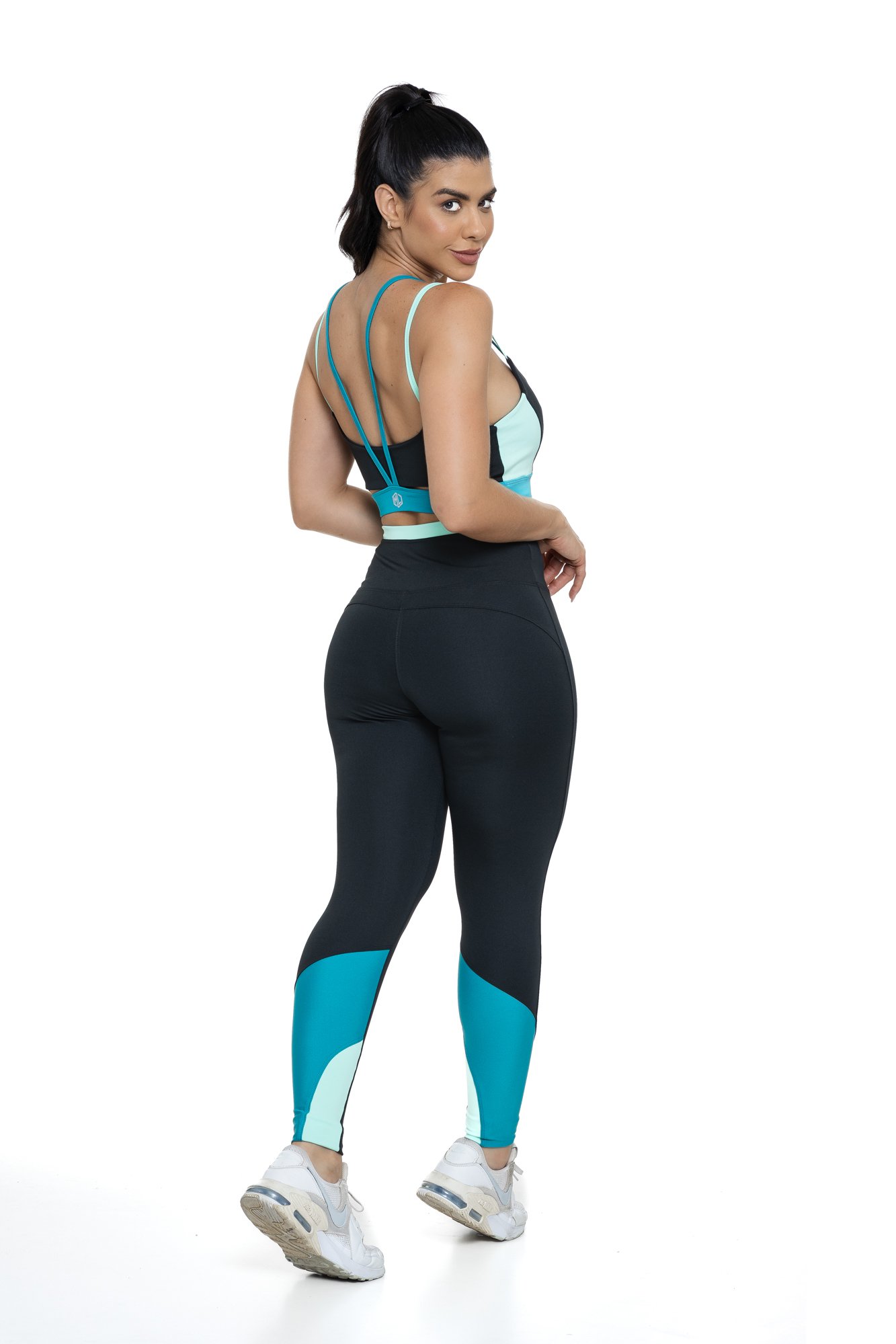 Conjunto fitness preto e verde com recortes visto de costas, projetado para conforto e mobilidade, ideal para treinos com estilo e praticidade.