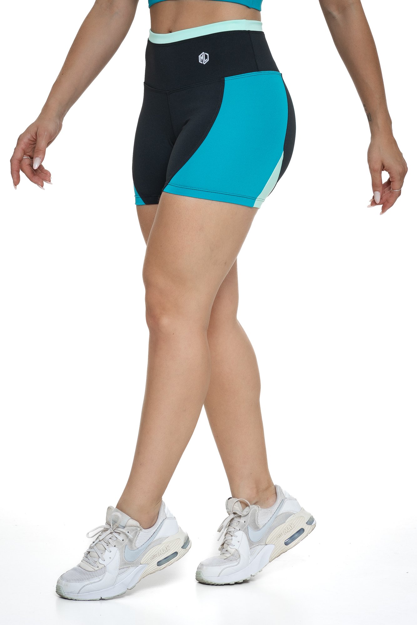 Bermuda fitness preto e verde com recortes visto de lado, projetado para conforto e mobilidade, ideal para treinos com estilo e praticidade.