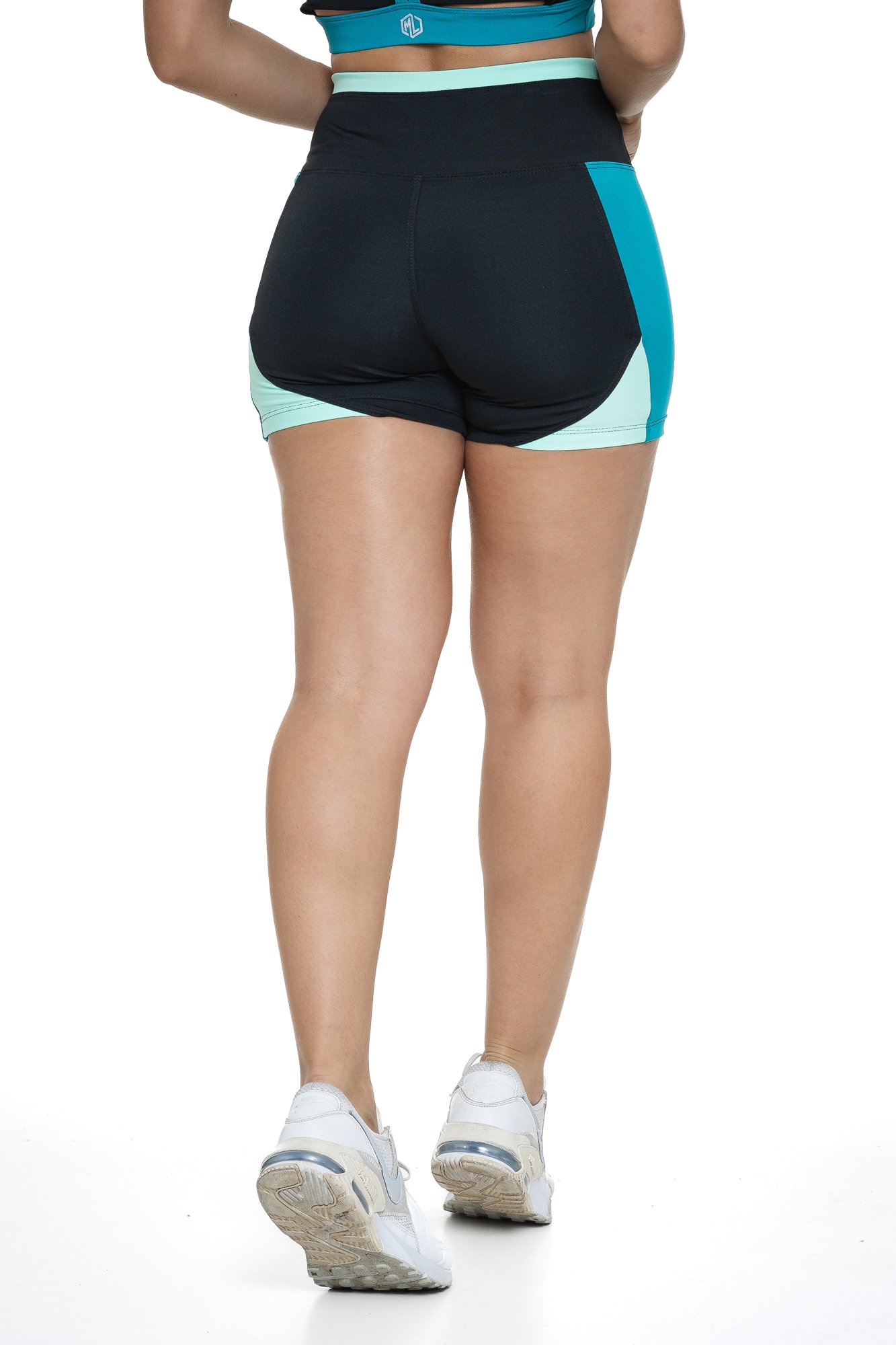 Bermuda fitness preto e verde com recortes visto de costas, projetado para conforto e mobilidade, ideal para treinos com estilo e praticidade.