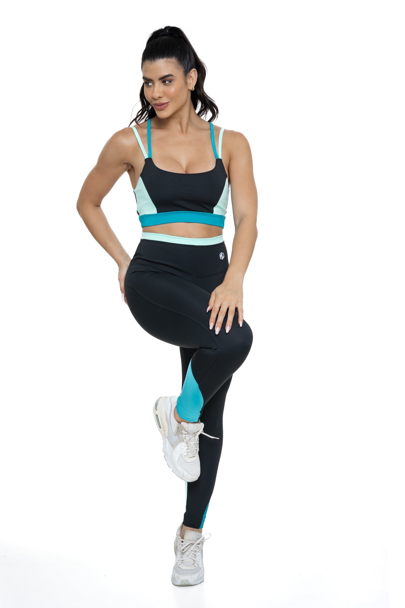 Conjunto fitness preto e verde com recortes visto de lado, projetado para conforto e mobilidade, ideal para treinos com estilo e praticidade.