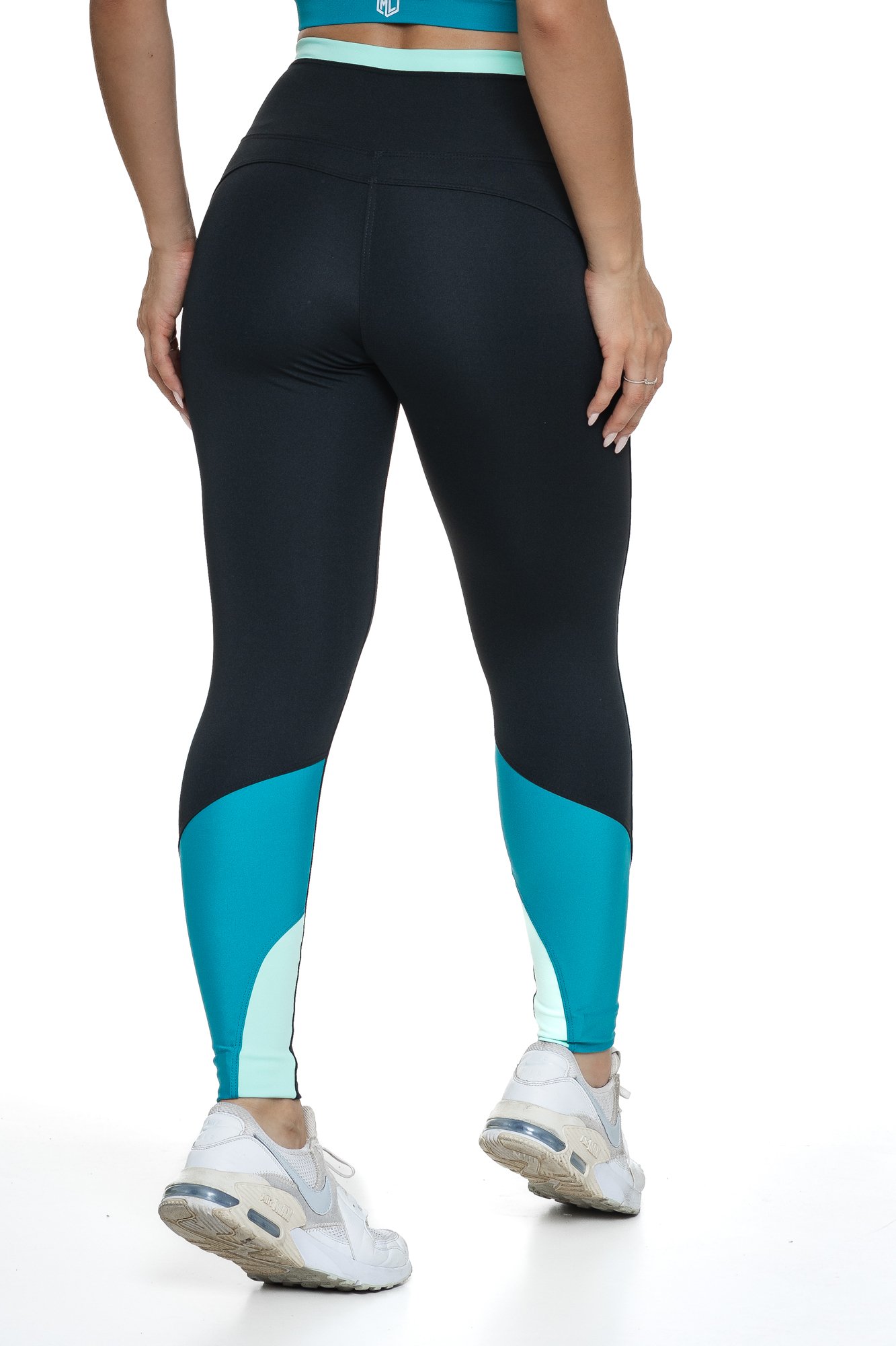 Legging fitness preto e verde com recortes visto de costas, projetado para conforto e mobilidade, ideal para treinos com estilo e praticidade.