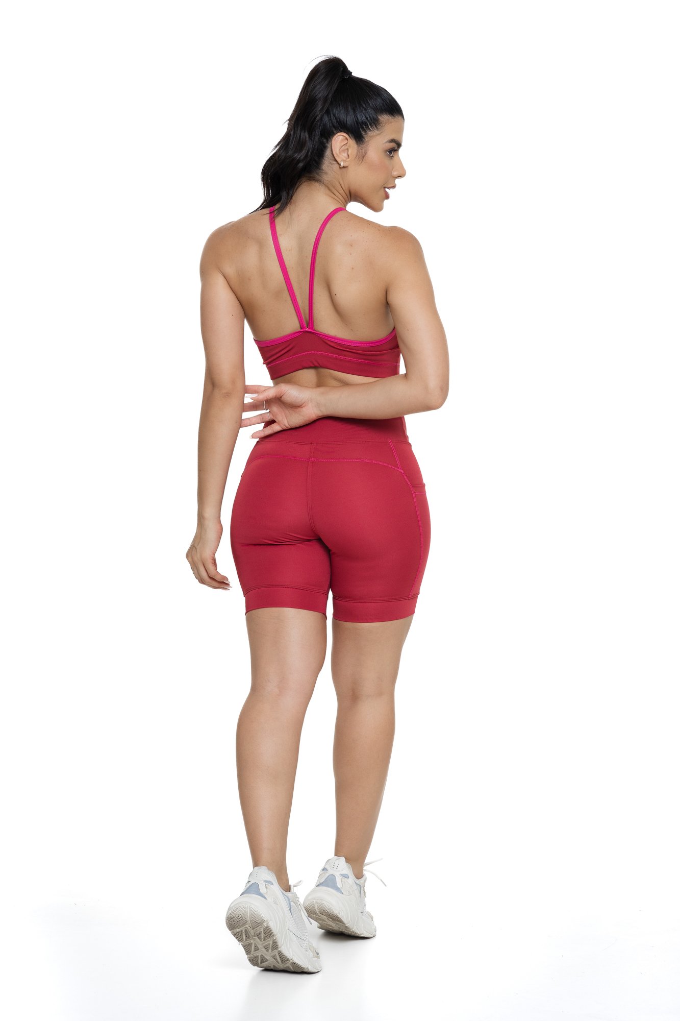 Conjunto bermuda feminino bordô e magenta com bolso visto de costas, ideal para treinos com estilo e praticidade.