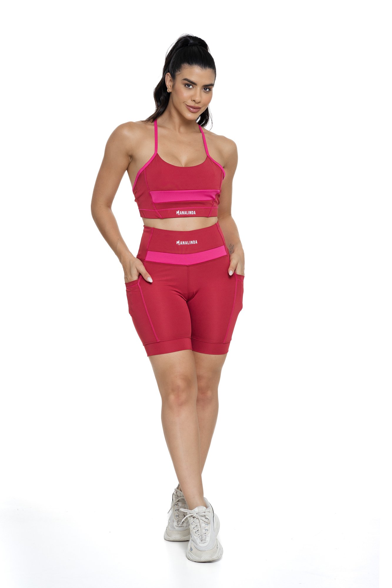 Conjunto bermuda feminino bordô e magenta com bolso visto de frente, ideal para treinos com estilo e praticidade.