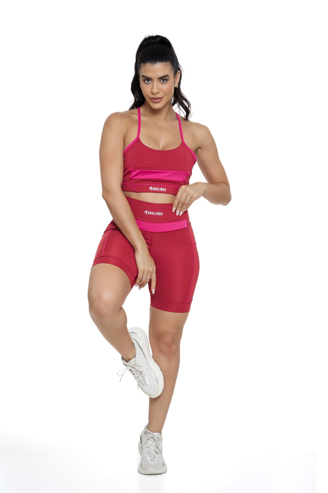 Conjunto bermuda feminino bordô e magenta com bolso visto de frente, ideal para treinos com estilo e praticidade.
