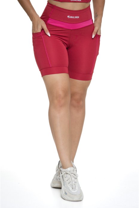 Bermuda feminina bordô e magenta com bolso visto de frente, projetado para conforto e mobilidade, ideal para treinos com estilo e praticidade.