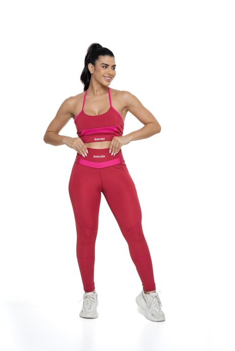 Conjunto feminino bordô e magenta com recortes visto de frente, projetado para conforto e mobilidade, ideal para treinos com estilo e praticidade.