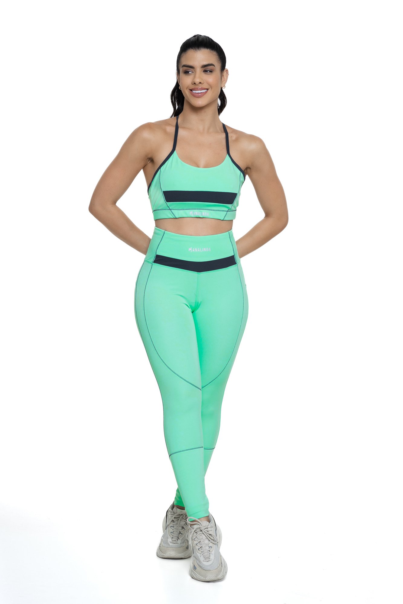 Conjunto feminino verde água e grafite com recortes visto de frente, projetado para conforto e mobilidade, ideal para treinos com estilo e praticidade