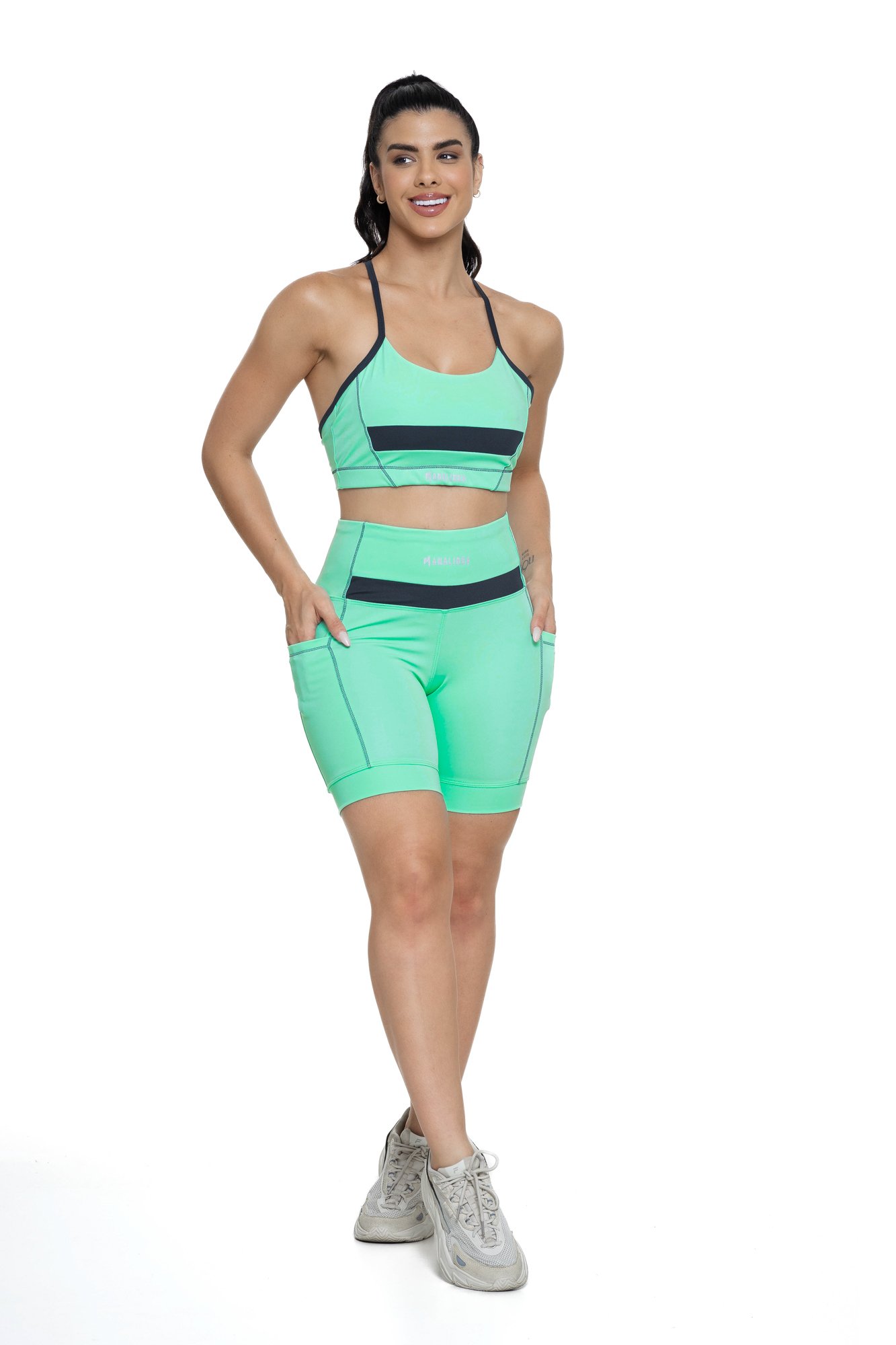 Conjunto bermuda feminino verde água e grafite com bolso visto de frente, ideal para treinos com estilo e praticidade.