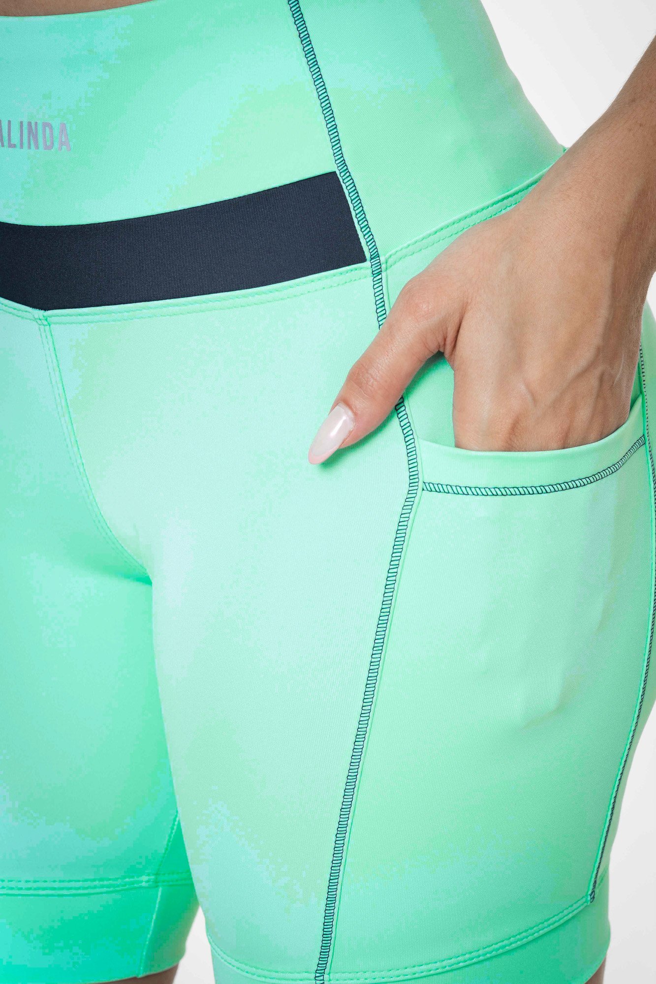 Bermuda feminina verde água e grafite com bolso, projetado para conforto e mobilidade, ideal para treinos com estilo e praticidade.