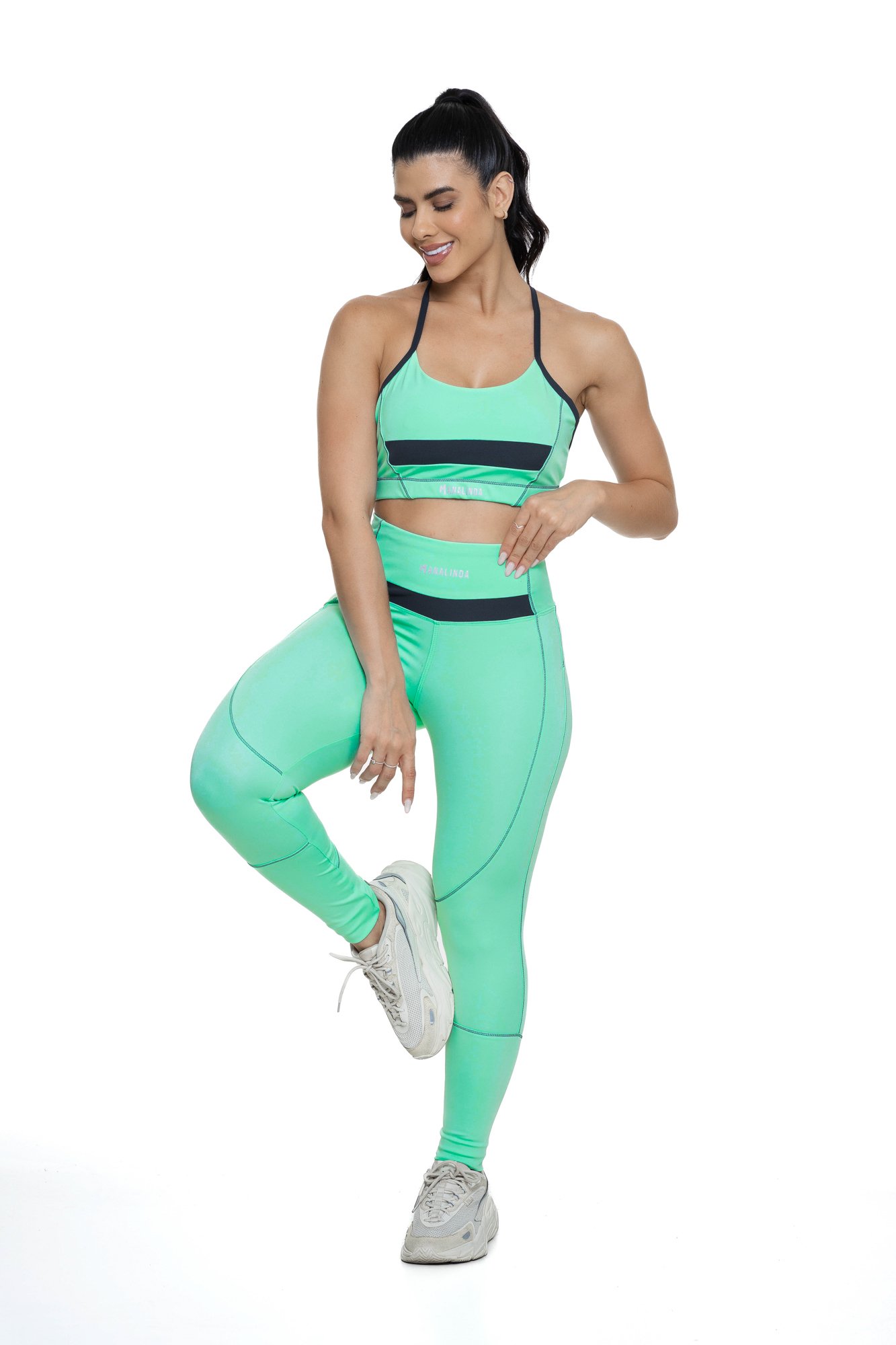 Conjunto feminino verde água e grafite com recortes visto de frente, projetado para conforto e mobilidade, ideal para treinos com estilo e praticidade