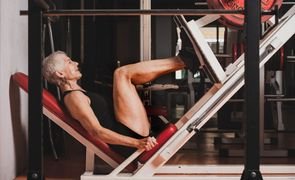 mulher fazendo legpress na academia