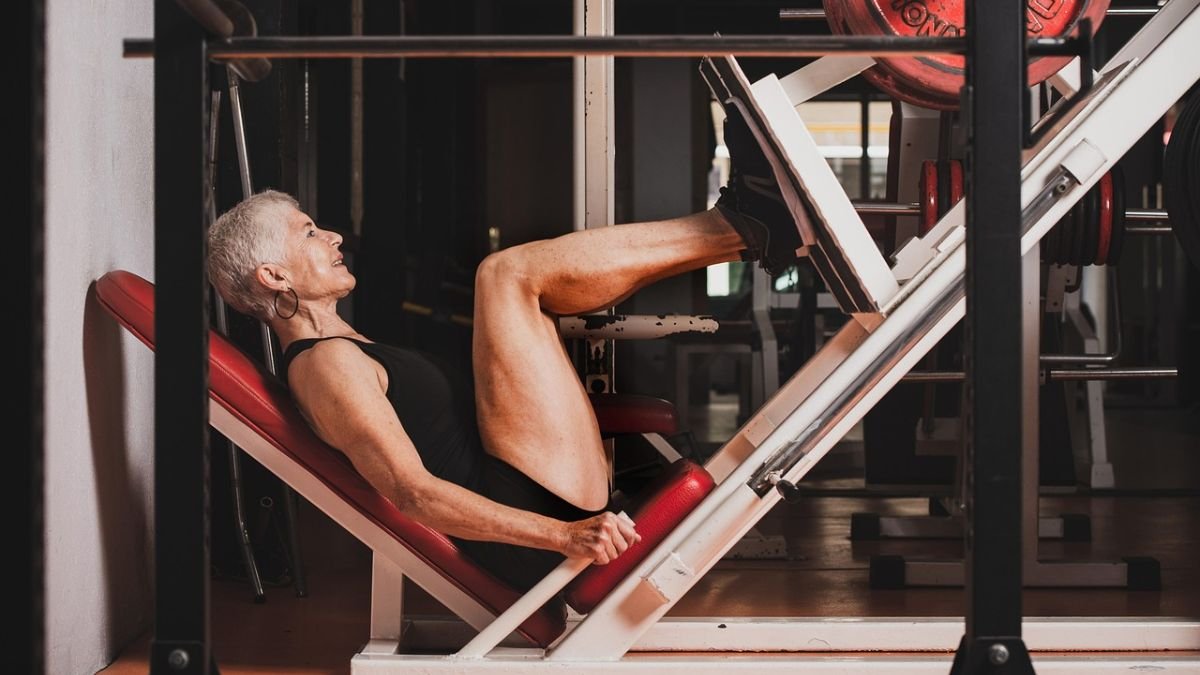 mulher fazendo legpress na academia